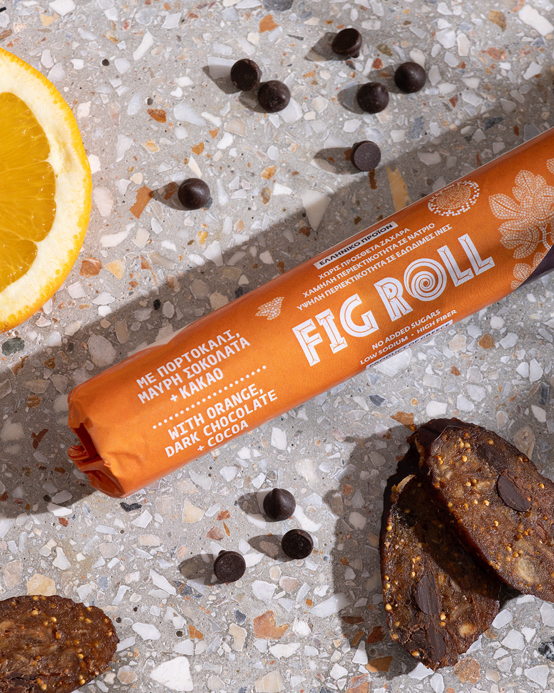 Feigenroll-Packung FIG ROLL in Orange auf hellen Steinchen mit Schokoladenstücken